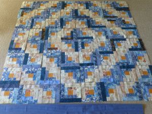Log cabin quilt vlocks laid out in barn raising setting
